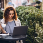 young-businesswoman-working-computer-outside-cafe_1303-18759